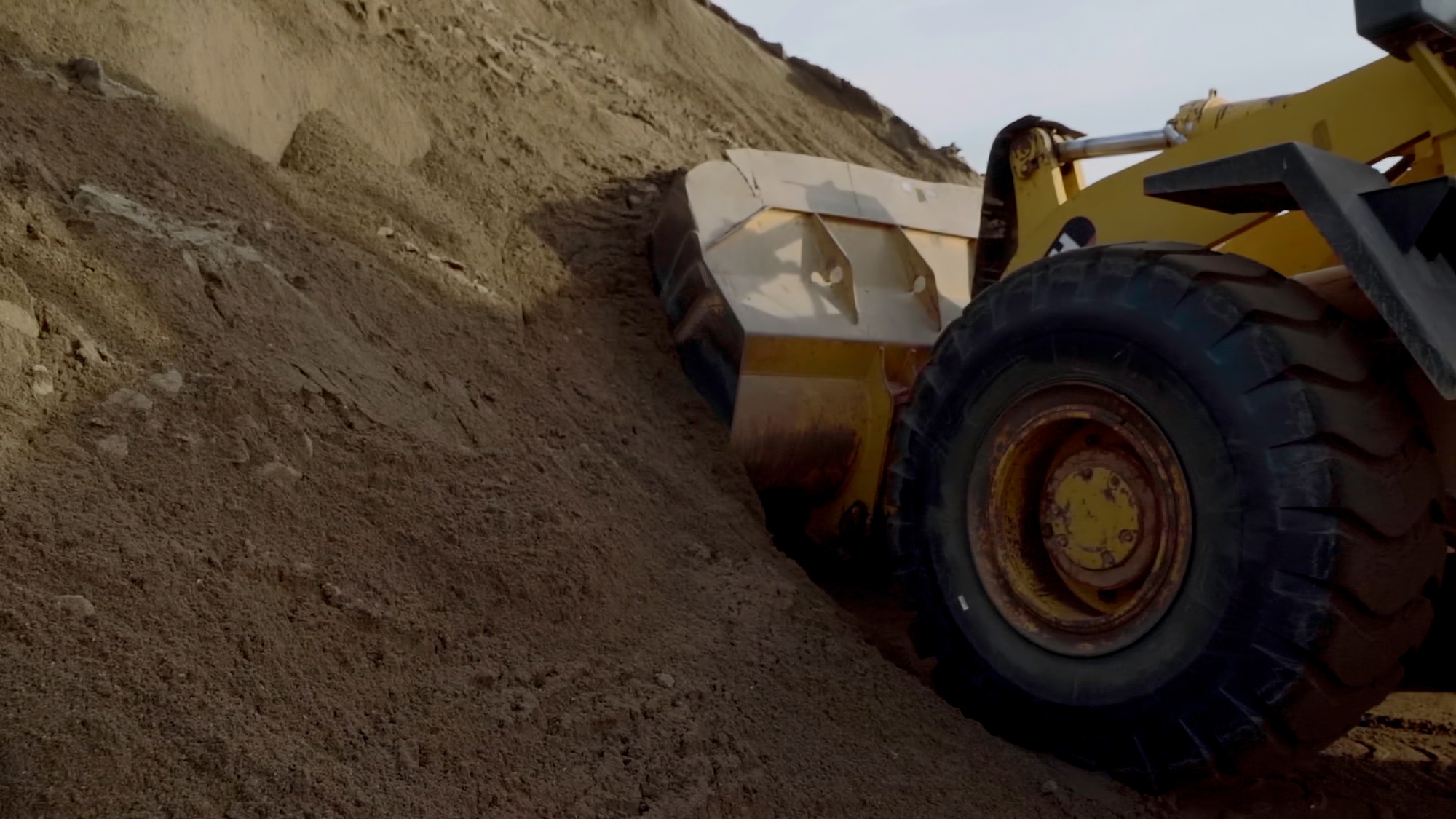 View from the bottom .Scene.Large tractors on an empty mountain , the construction process.